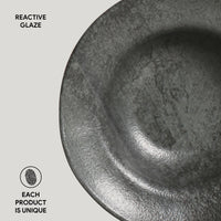 Close-up of a ceramic bowl with reactive glaze on a light gray background