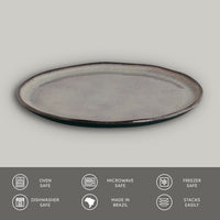 Oval ceramic plate with rustic finish on a light gray background