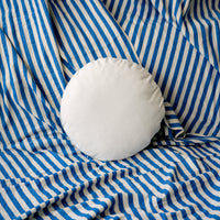 White round pillow on blue and white striped fabric