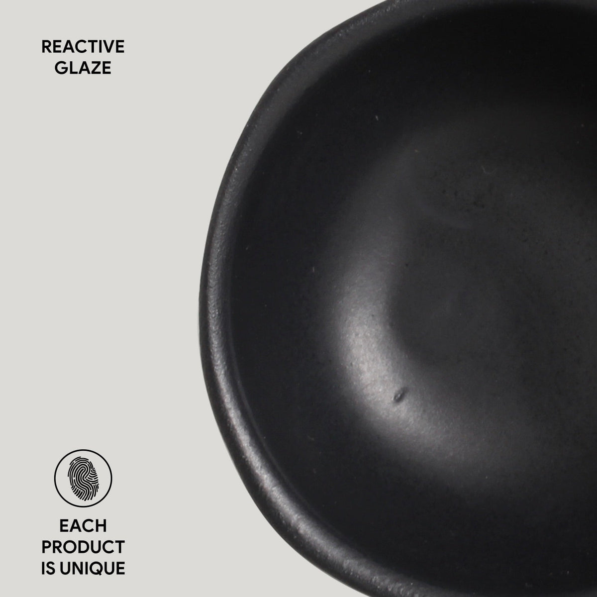Black ceramic bowl with 'Reactive Glaze' text and 'Each product is unique' label on a light gray background