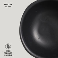 Black ceramic bowl with 'Reactive Glaze' text and 'Each product is unique' label on a light gray background