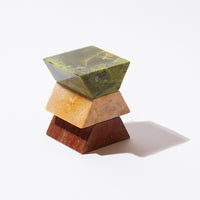Three-tiered stone object with green, yellow, and brown colors on a white background