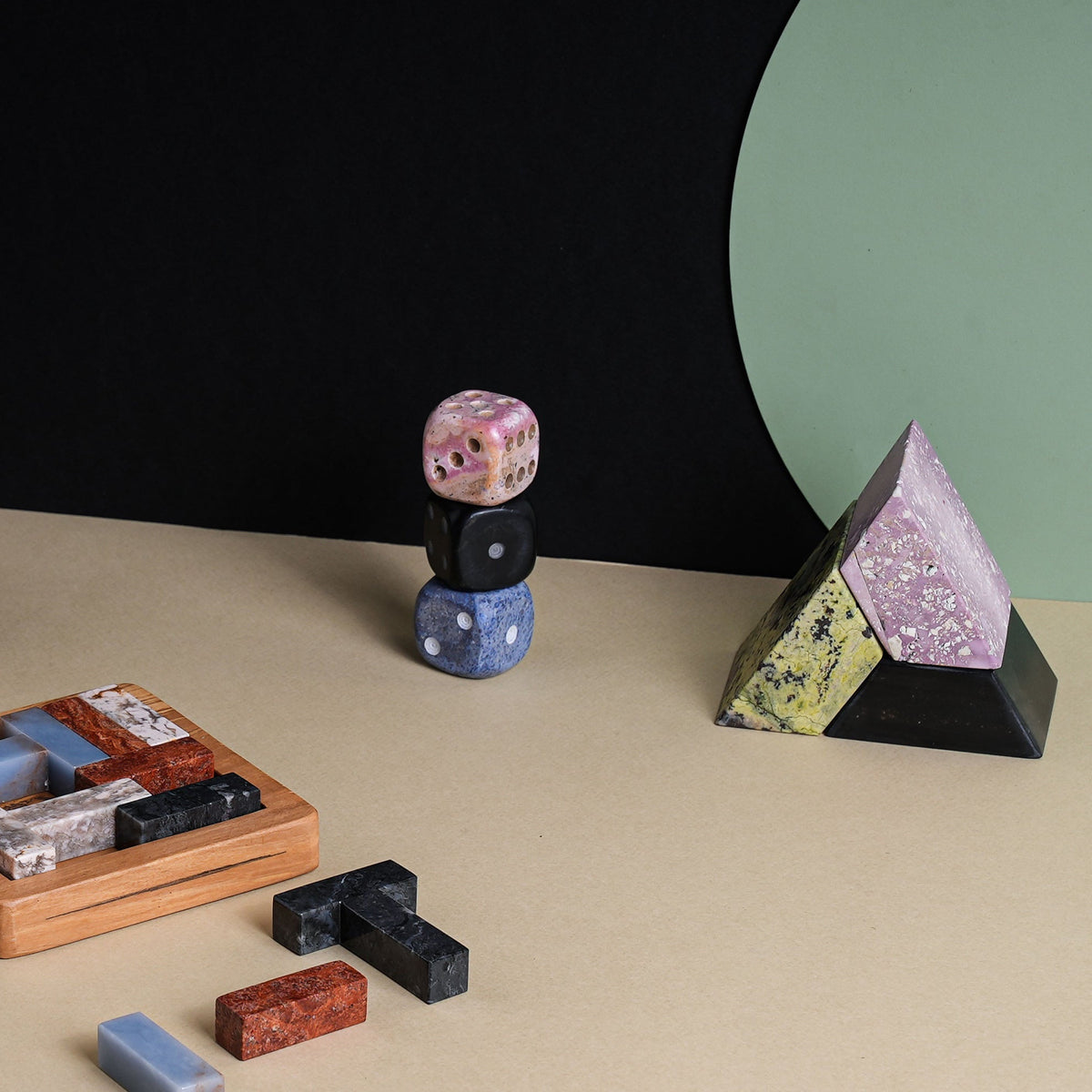 stack of stone dice and other colorful stone objects on a neutral surface