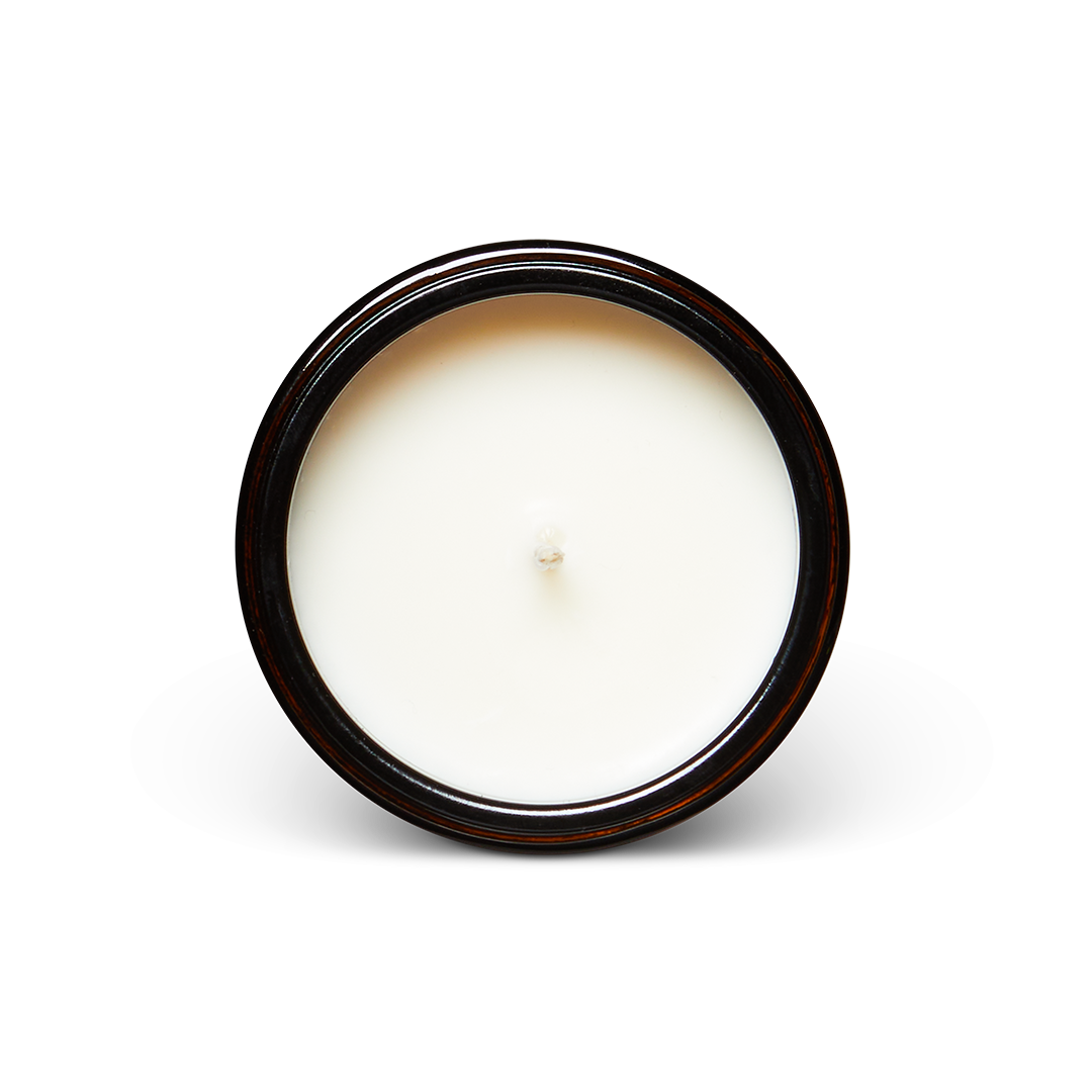Top view of a new soy wax candle in a dark glass jar