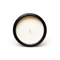 Top view of a new soy wax candle in a dark glass jar