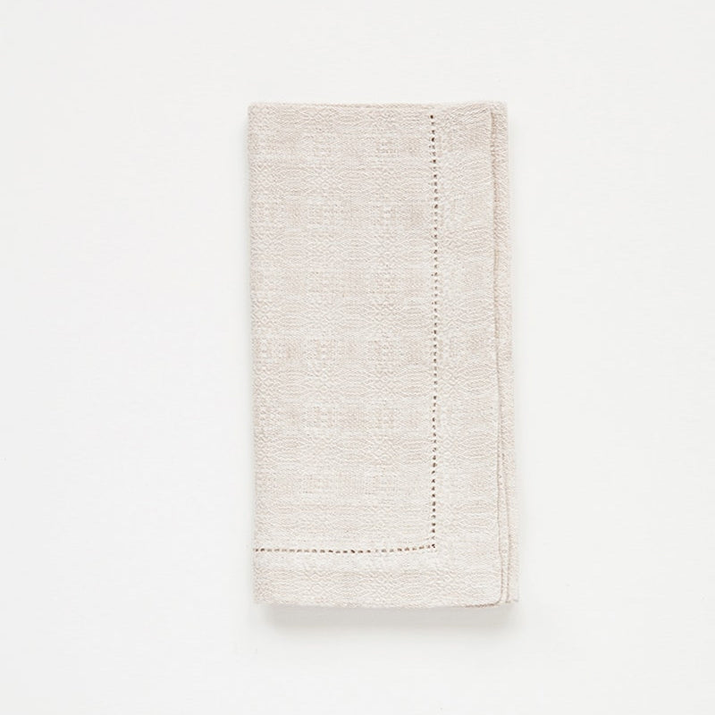 Folded beige napkin on a white background