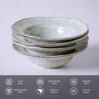 Stack of ceramic bowls with speckled texture on a light gray background