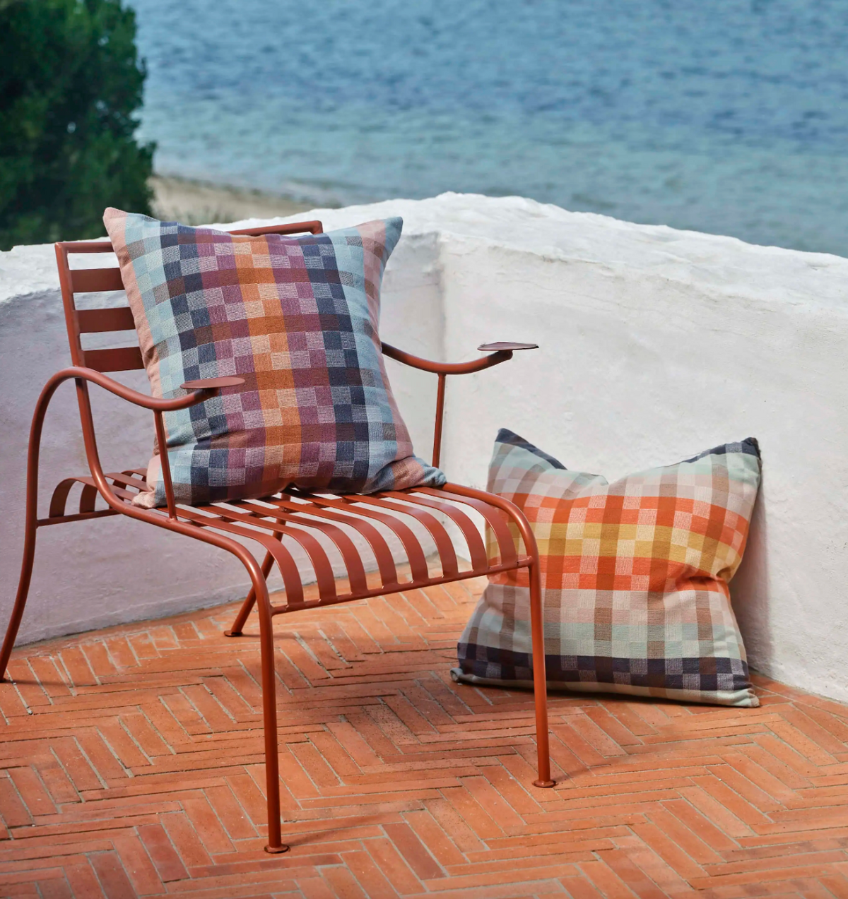 Chair with plaid cushions on a patio by the water