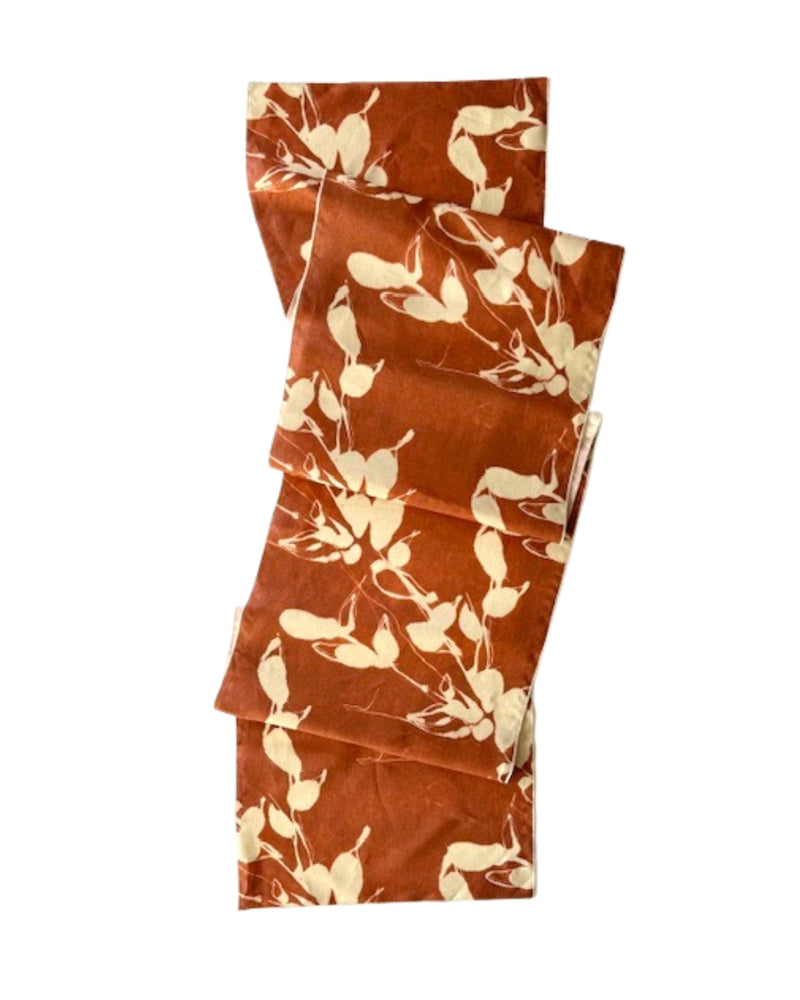 Set of folded fabric table runner with floral pattern on a white background