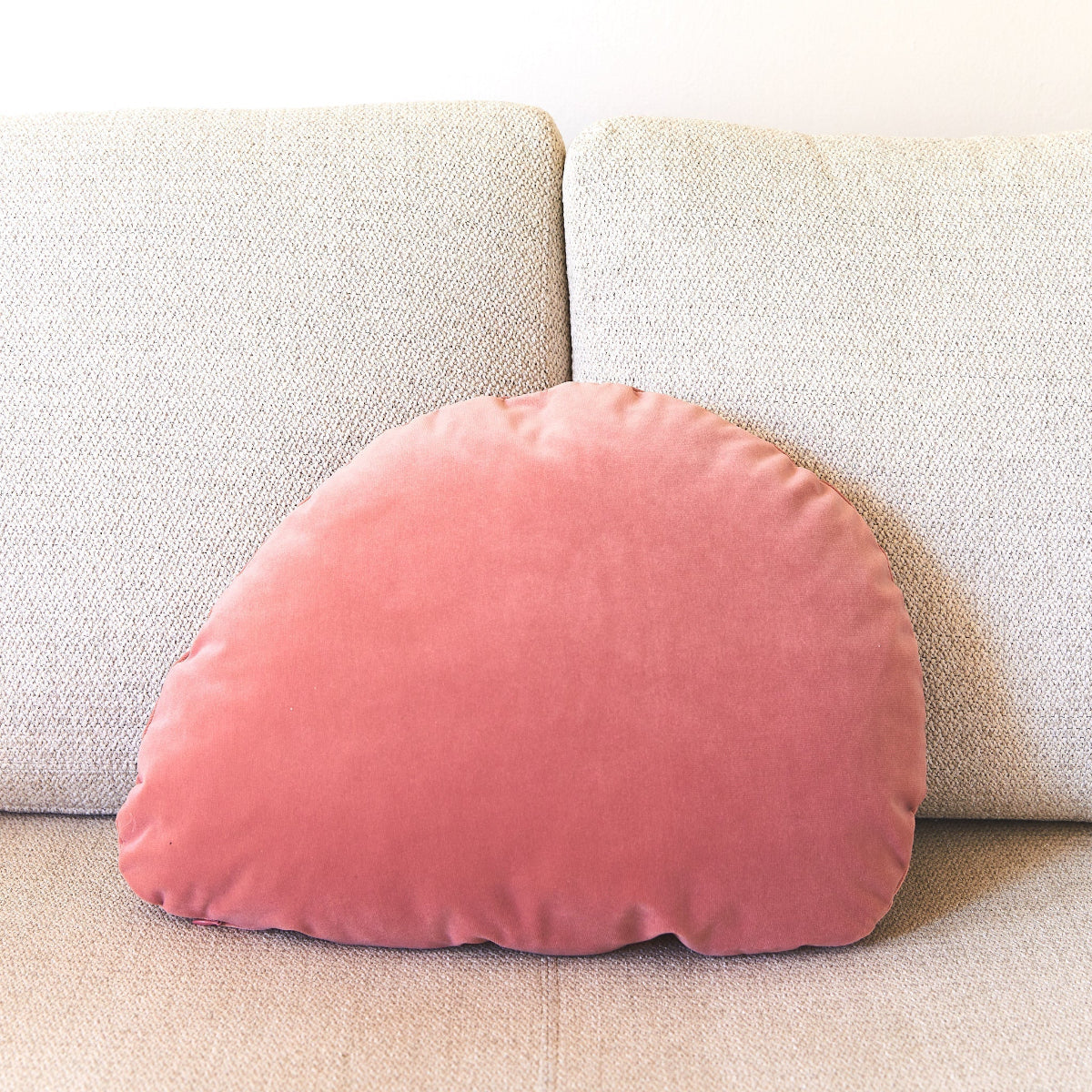 Pink velvet pillow on a beige sofa
