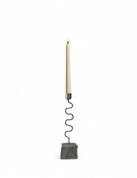 Wavy metal and stone candle holder with a candle on a white background