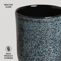 Ceramic mug with reactive glaze pattern on a light gray background
