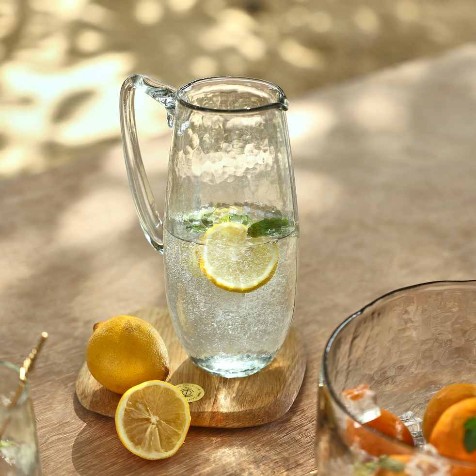 Pebbled Glass Pitcher with fruit infused water on a table outside