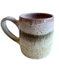 Ceramic mug with light and dark neutral and pink glaze details on a white background