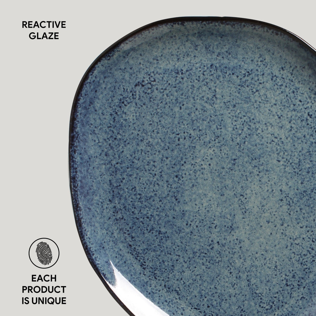 Blue ceramic plate with reactive glaze on a light gray background