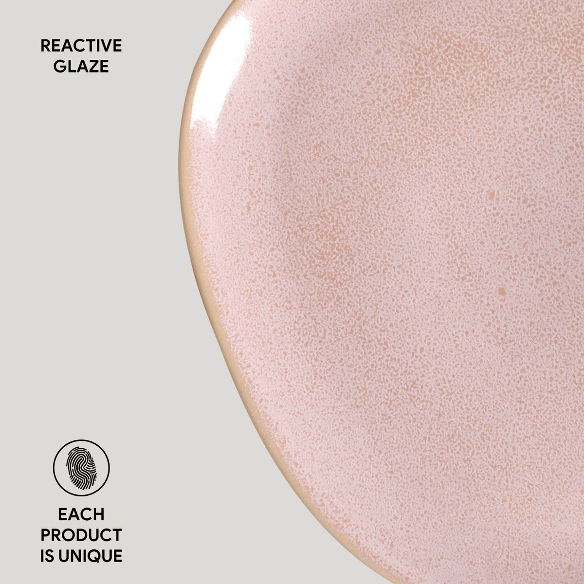 Close-up of a pink ceramic plate with reactive glaze on a light gray background