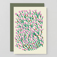 Card with floral pattern and green envelope on light gray background