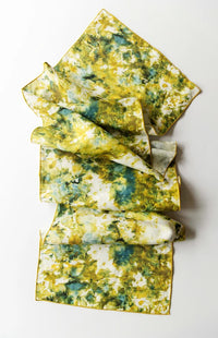 Green and gold marbled table runner with gold trim on a white background