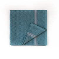 Teal towel with striped border on a white background
