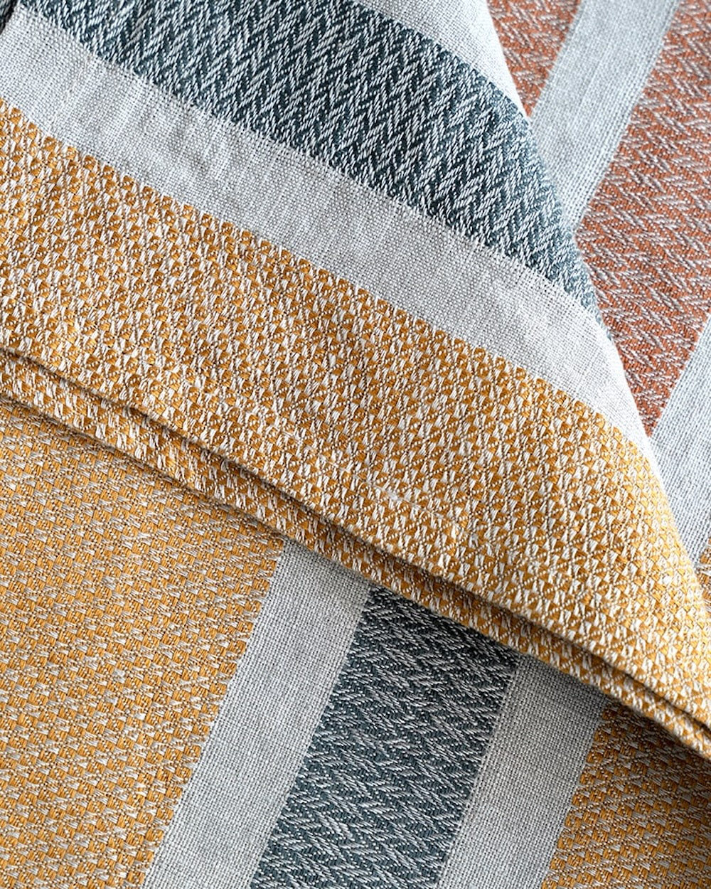 Close-up of woven towel fabric in gold, gray, and white.
