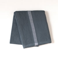 Folded blue hand towel with a white stripe