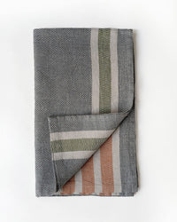 Folded woven towel with striped pattern on a white background