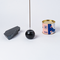 Black spherical object with a stick, gray rectangular block, and colorful can on a white background