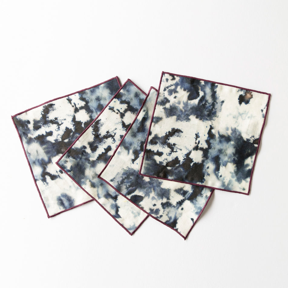 Set of four tie-dye cocktail napkins with a white background