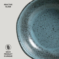 Blue ceramic plate with reactive glaze on a light gray background