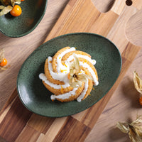 Green plate with a dessert on a wooden table