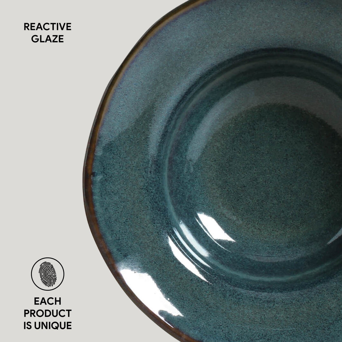 Teal ceramic bowl with reactive glaze on a light gray background