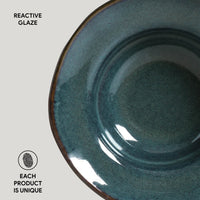 Teal ceramic bowl with reactive glaze on a light gray background