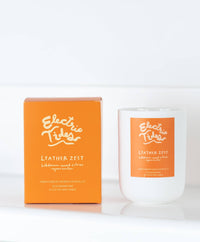 Electric Tides Leather Zest candle and packaging on a white background