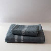 Folded blue textured towels on a white surface