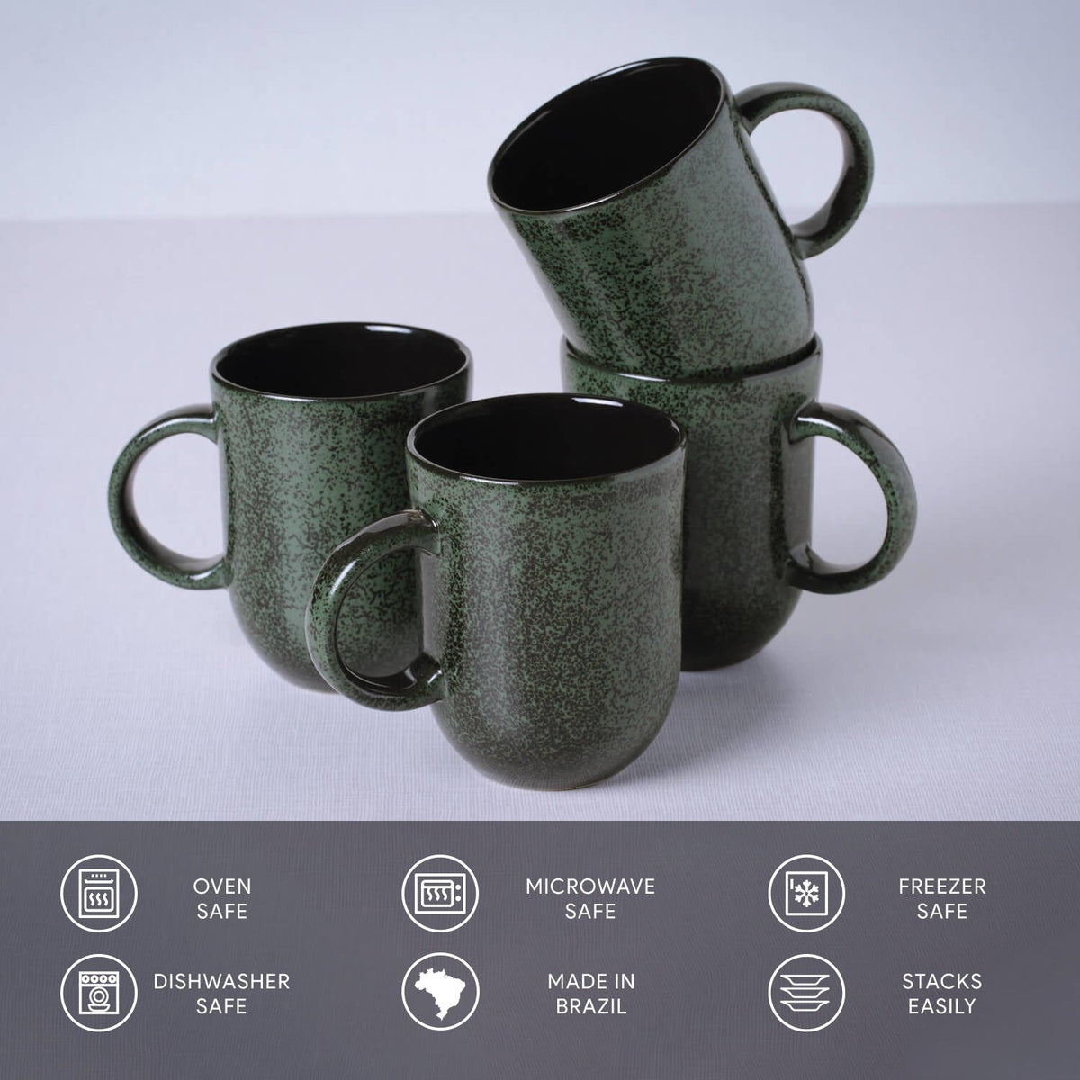 Set of green ceramic mugs with handles on a light gray background