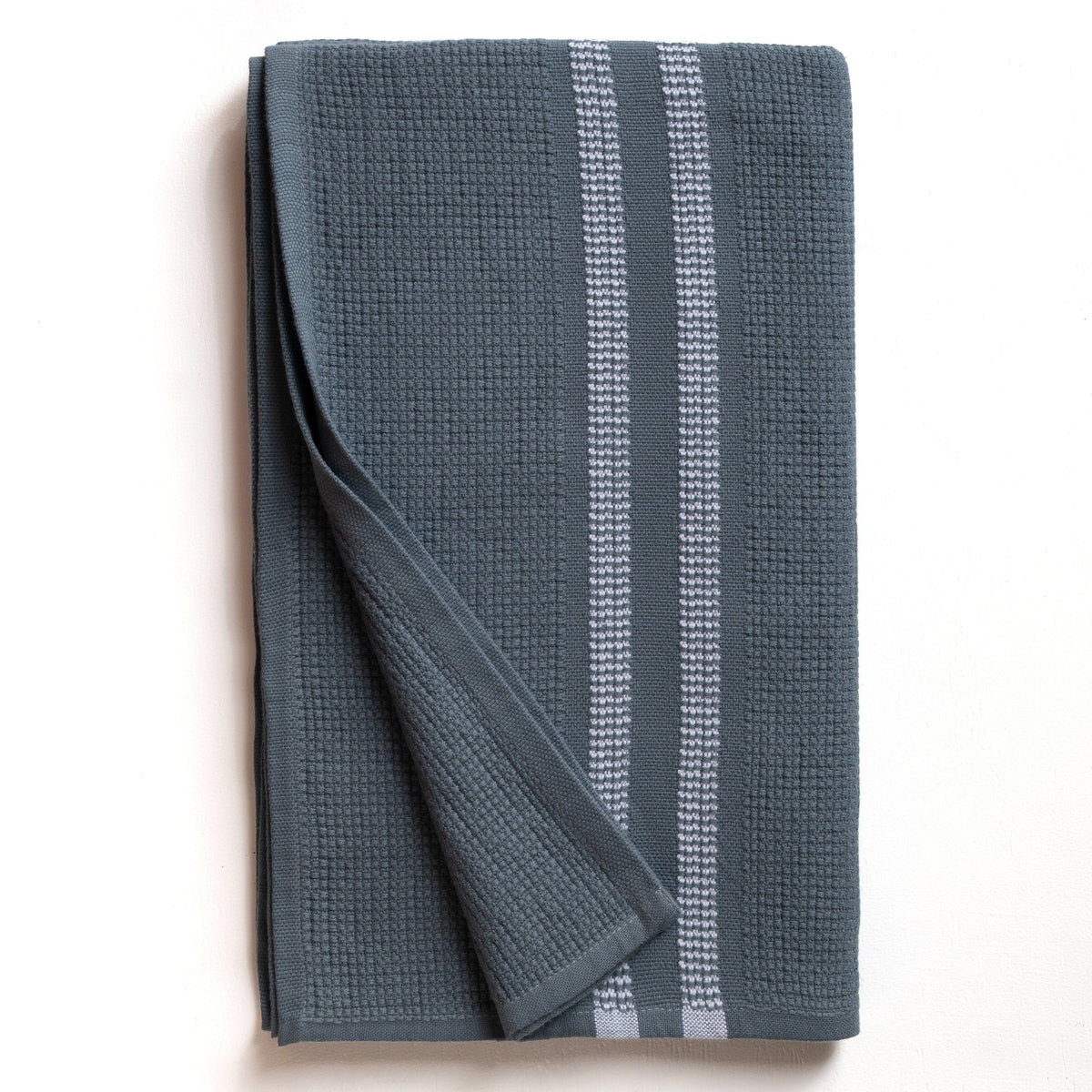 Folded blue bath towel with white stripes