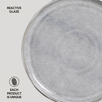 Gray ceramic plate with reactive glaze on a light gray background