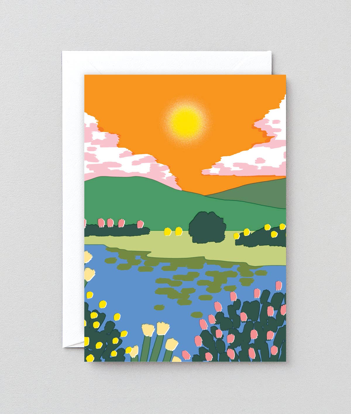 Greeting card with a colorful landscape design featuring a sunset, lake, and flowers on a gray background.
