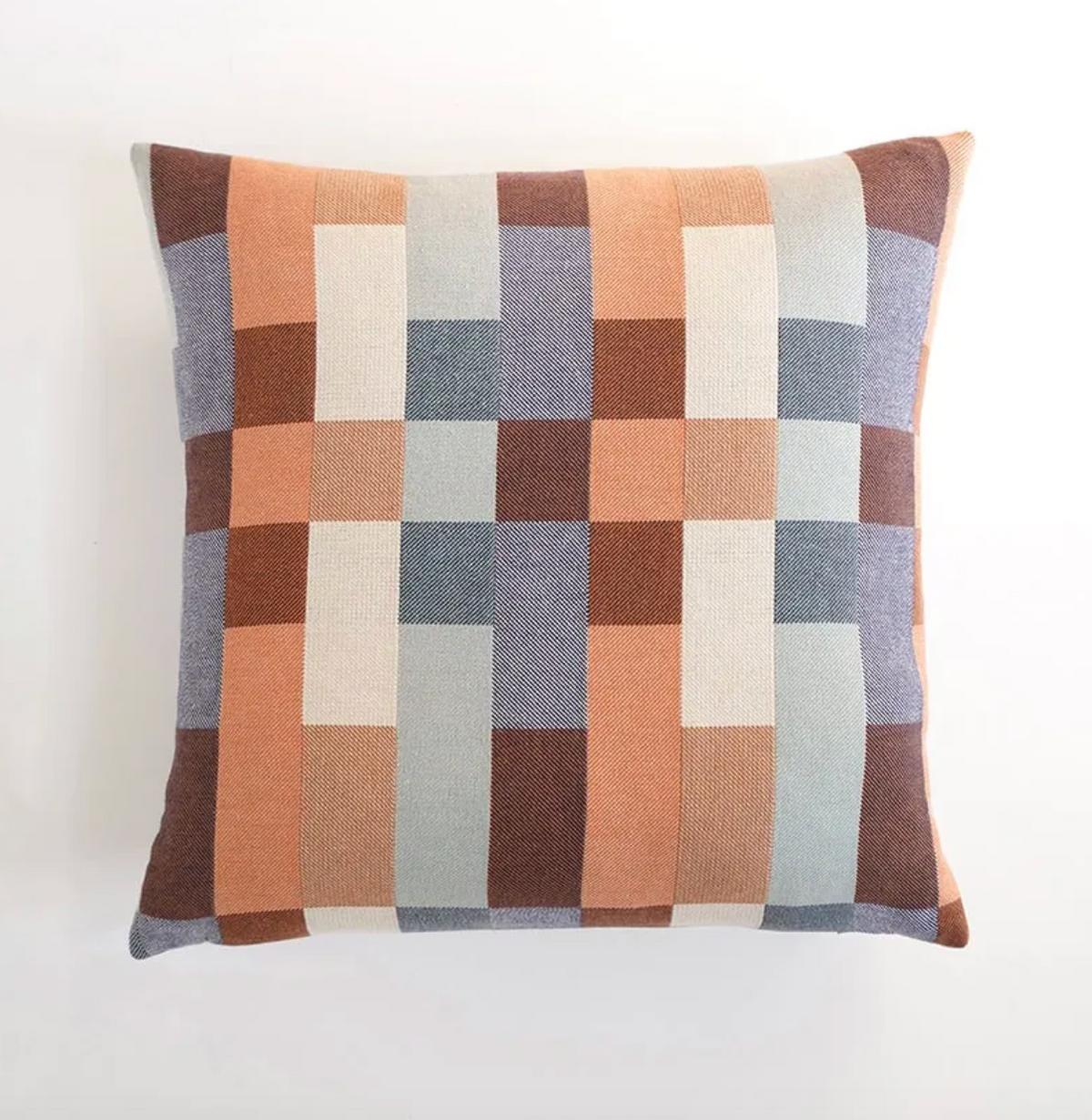 Checkered pillow with brown, blue, and beige squares on a white background
