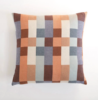 Checkered pillow with brown, blue, and beige squares on a white background