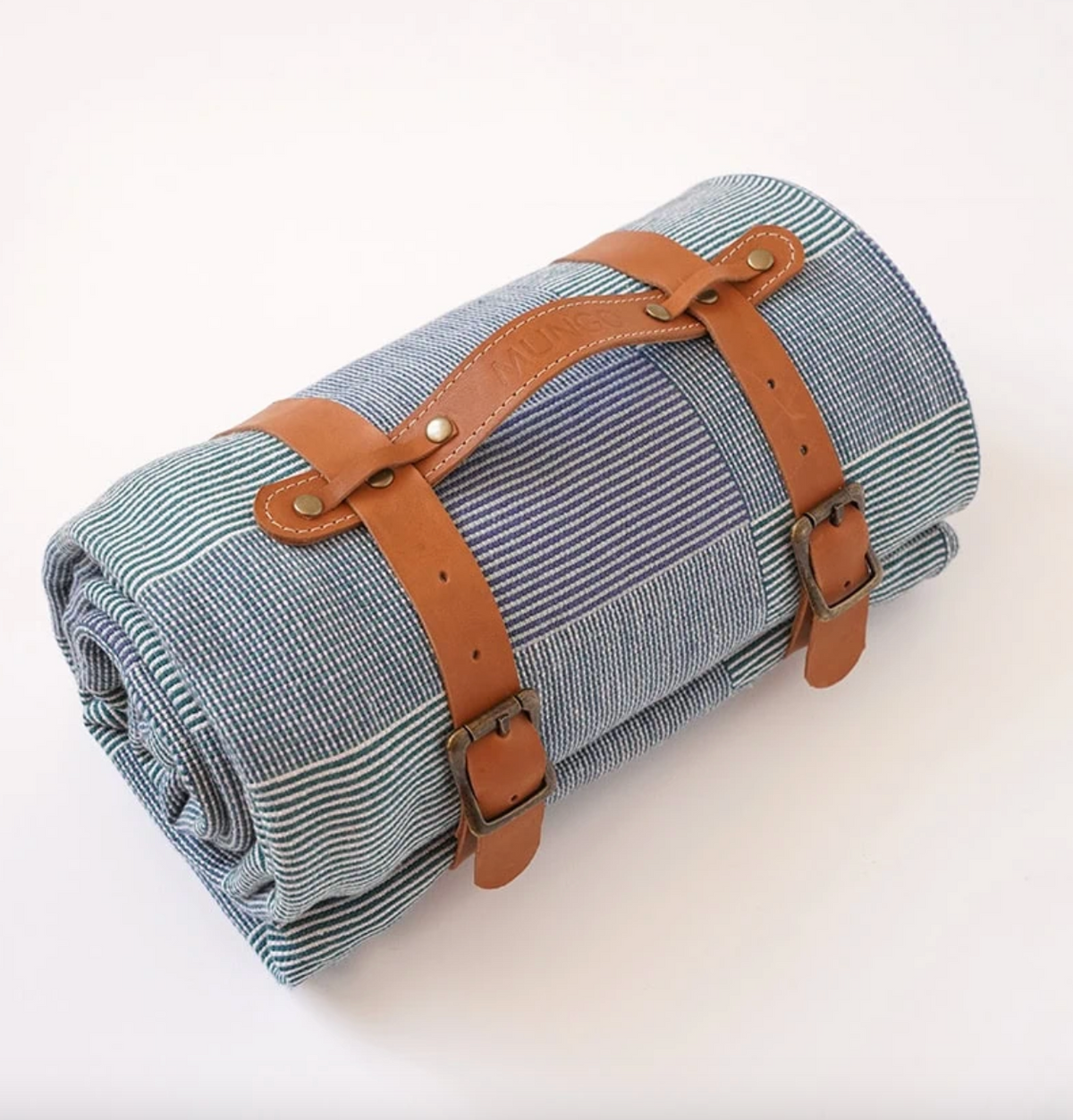 Roll-up picnic blanket with leather straps on a white background