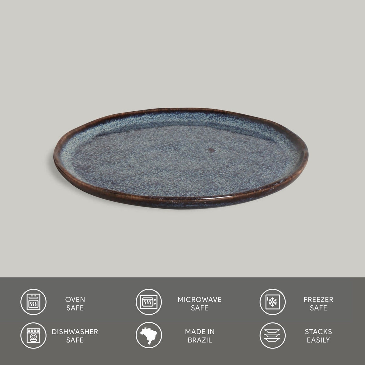 Round ceramic plate with blue speckled glaze on a gray background