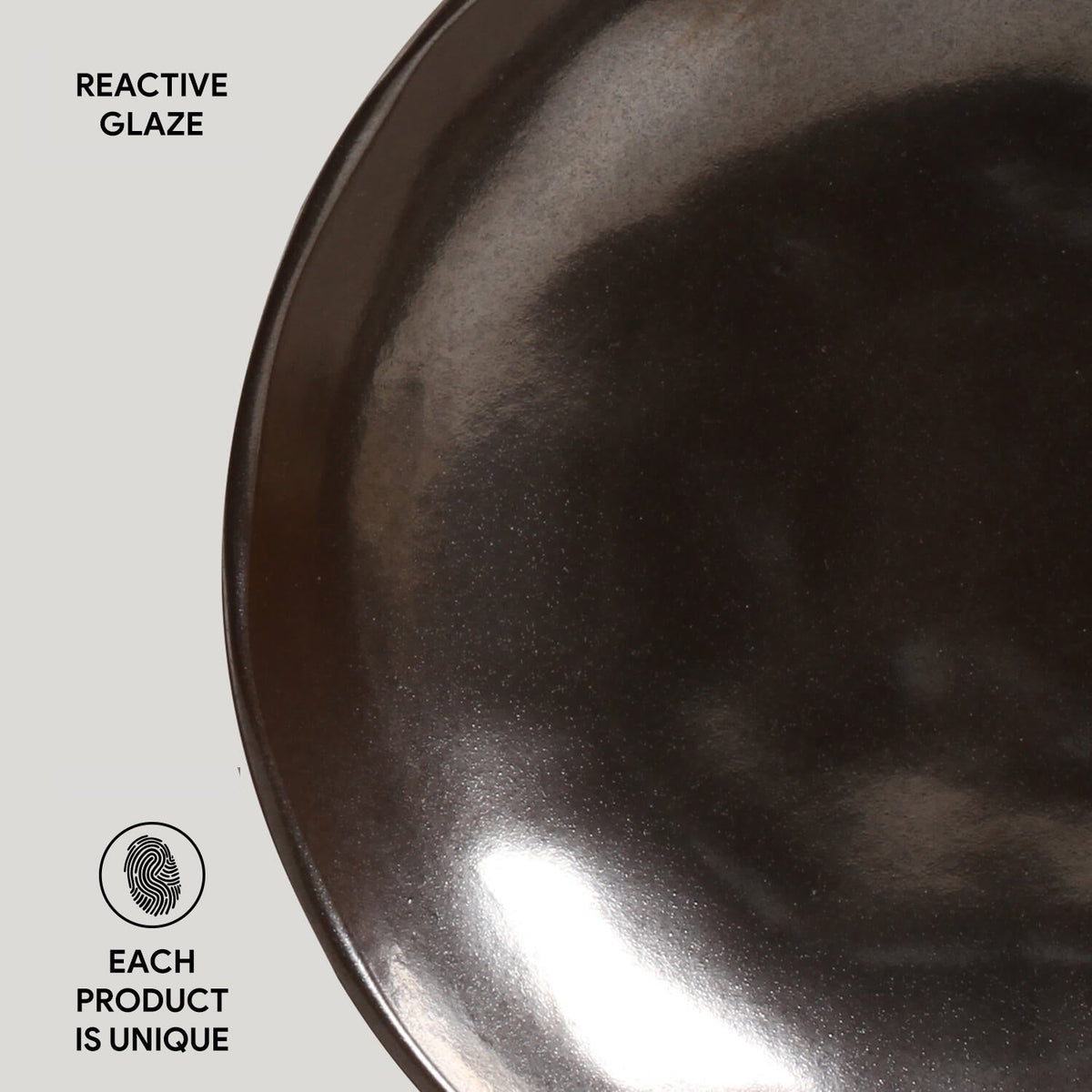 Close-up of a dark, textured ceramic bowl with 'Reactive Glaze' text and 'Each Product is Unique' label.