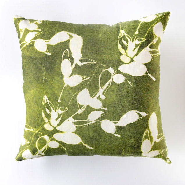Green pillow with white floral pattern on a white background