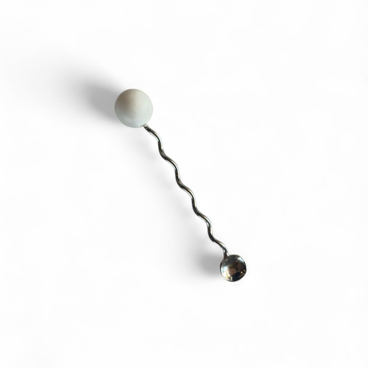 stainless steel squiggle beverage stirrer on white background