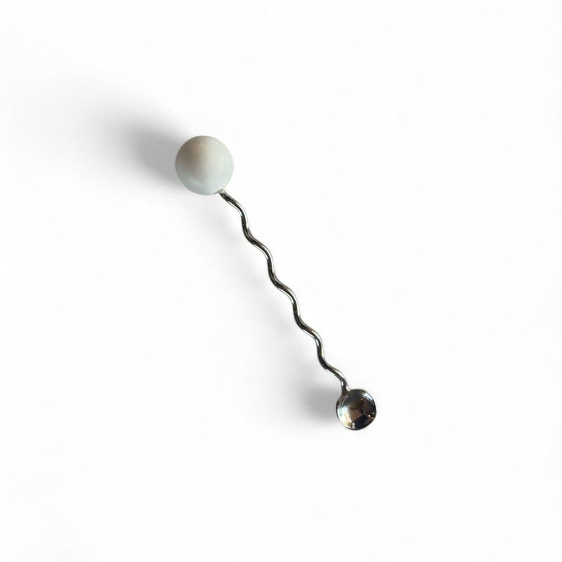 stainless steel squiggle beverage stirrer on white background