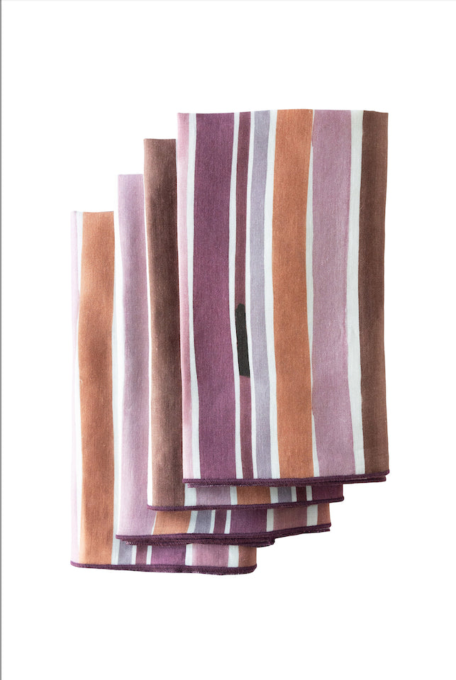 Stack of striped fabric napkins in purple, brown, and white on a white background