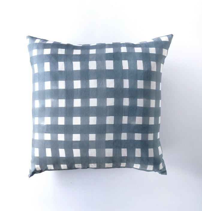 Checkered pillow with blue and white pattern on a white background