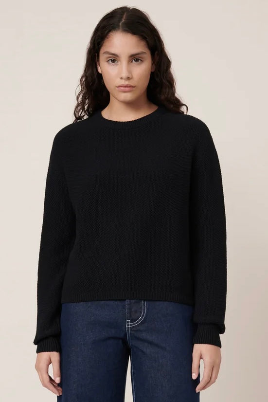 Woman wearing a black textured pullover sweater