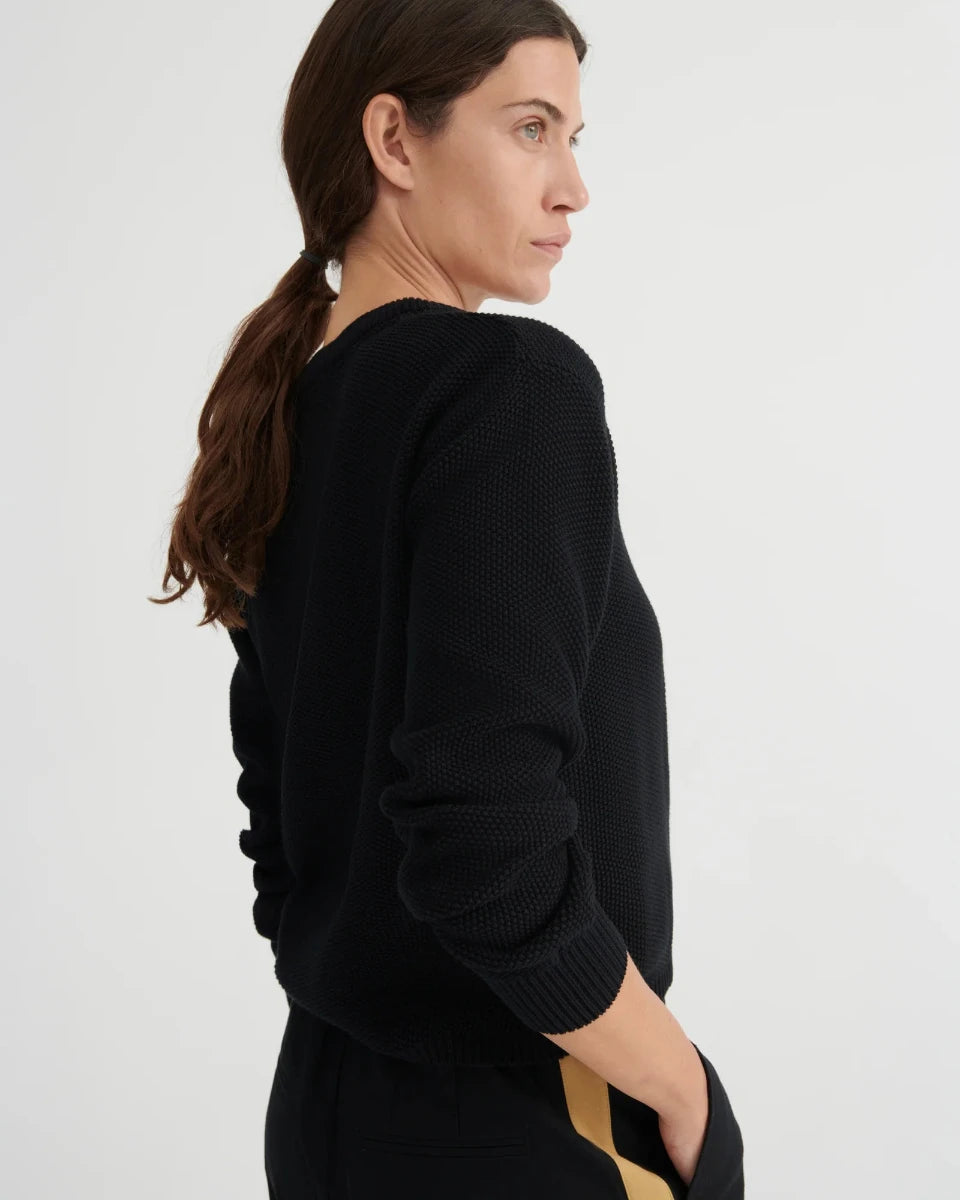 Woman wearing a black sweater with a white background